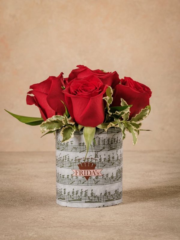 Red Rose Sushi, Frida's best seller. Bouquet of red roses wrapped in paper with a musical note design.