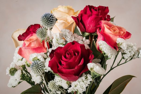 Bouquet Crispy rose rosse, rose chiare, eryngium e statice bianco