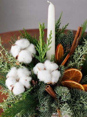 Centrotavola Bianco Natale candela bianca, fiori di cotone, fettine di arancia, bastoncini di cannella e mix di conifere