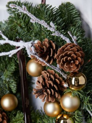 Ghirlanda, conifere con pigne e decorazioni natalizie