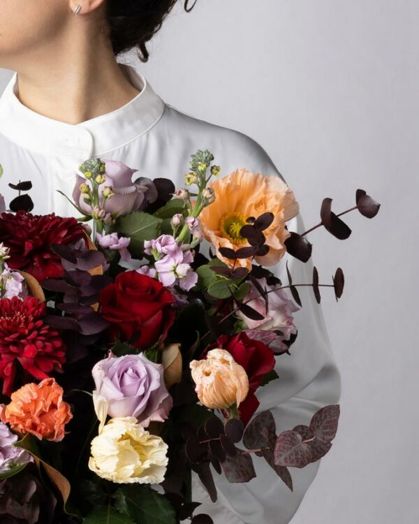 Rose rosse, crisantemi bordeaux, rose lilla, violaciocca lilla, papaveri colorati e verde di stagione nel Bouquet Incanto d'Amore