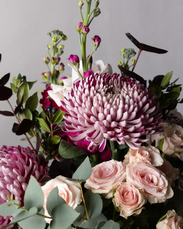 Roselline ramificate chiare, violaciocca fucsia e verede di stagione nel bouquet di fiori